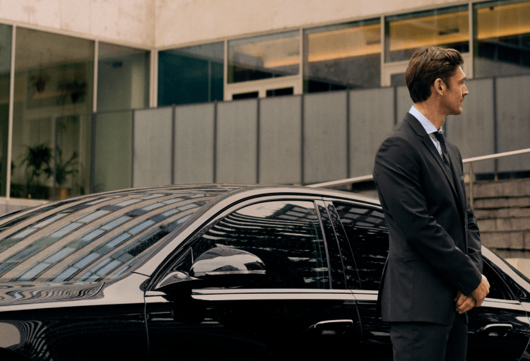 Chauffeur waiting outside his car
